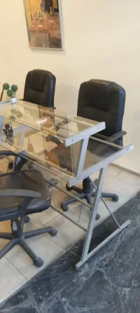Juego de escritorios de vidrio y metal y sillas con ruedas y apoyabrazos para oficina Belgrano