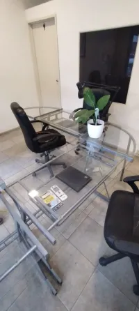 Juego de escritorios de vidrio y metal y sillas con ruedas y apoyabrazos para oficina Belgrano