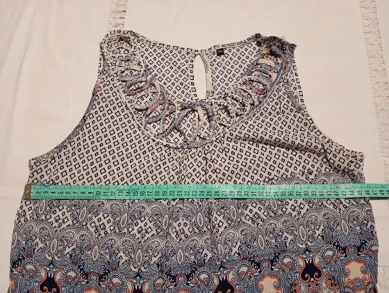 Musculosa delicada con detalle en cuello y pompones Floresta