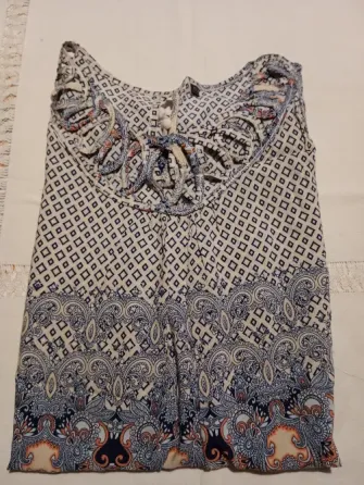 Musculosa delicada con detalle en cuello y pompones Floresta